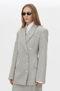 Three-quarter view CAMILLA AND MARC Aspira Blazer in Dusty Blue with a draped double‑breasted wool silhouette.