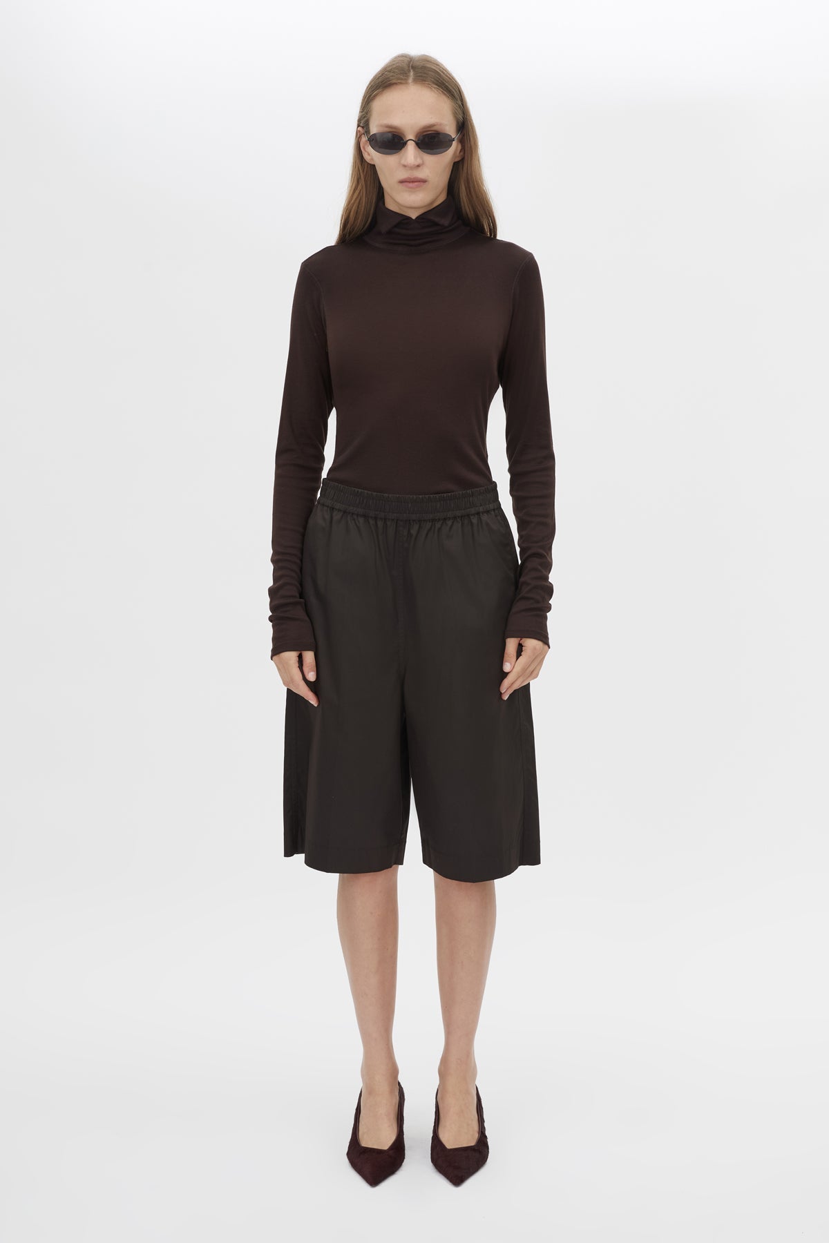Front styled view CAMILLA AND MARC Barre High Neck Top in Chocolate with long sleeves and turtleneck silhouette.  