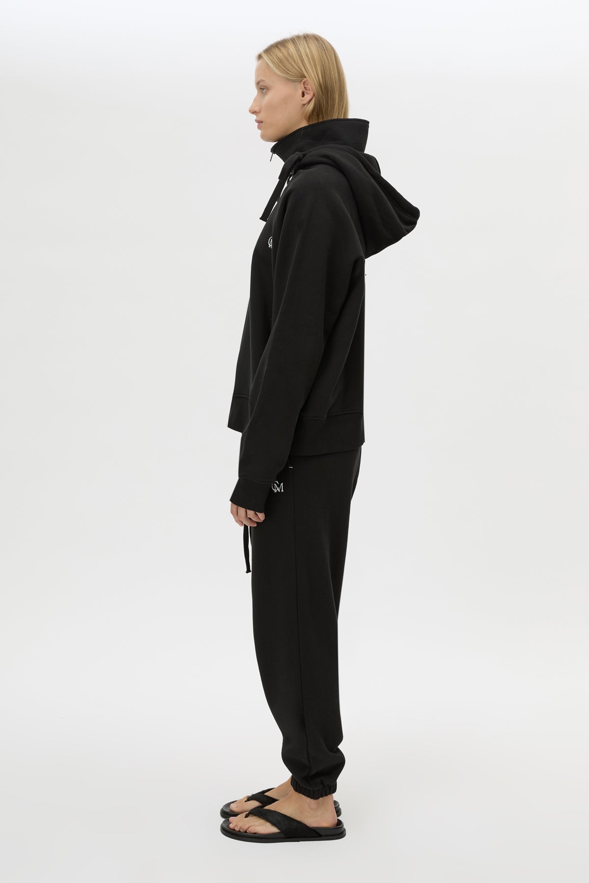 Side view CAMILLA AND MARC Lyra Embroidered Hoodie in Black and White with exposed quarter‑zip opening.