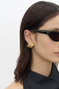 Model Side View CAMILLA AND MARC Odin Stud Earrings 18k gold plated geometric studs.