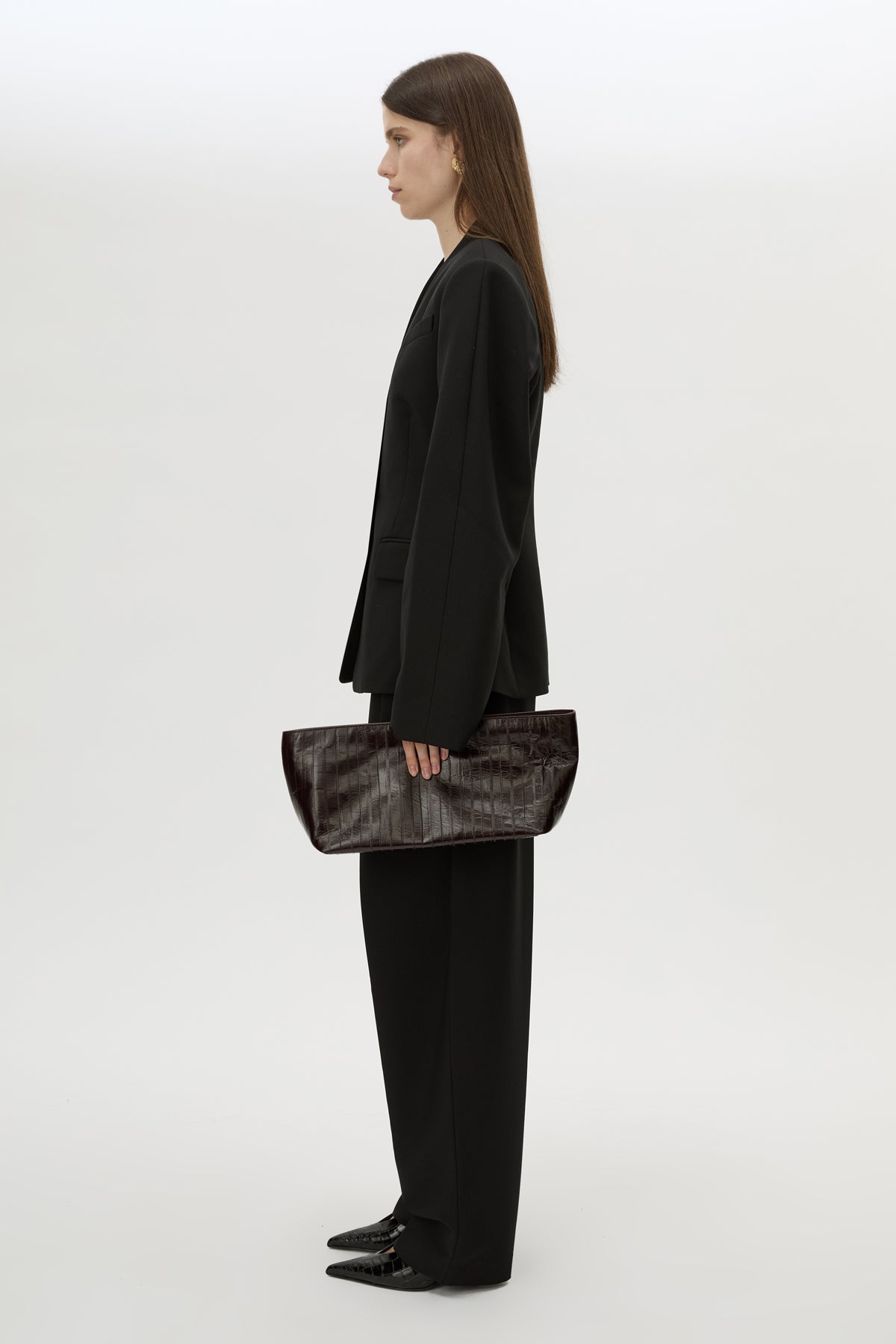 Front styled view CAMILLA AND MARC Poppy Eel Clutch in Burgundy eel‑embossed leather with ribbed gold hardware.