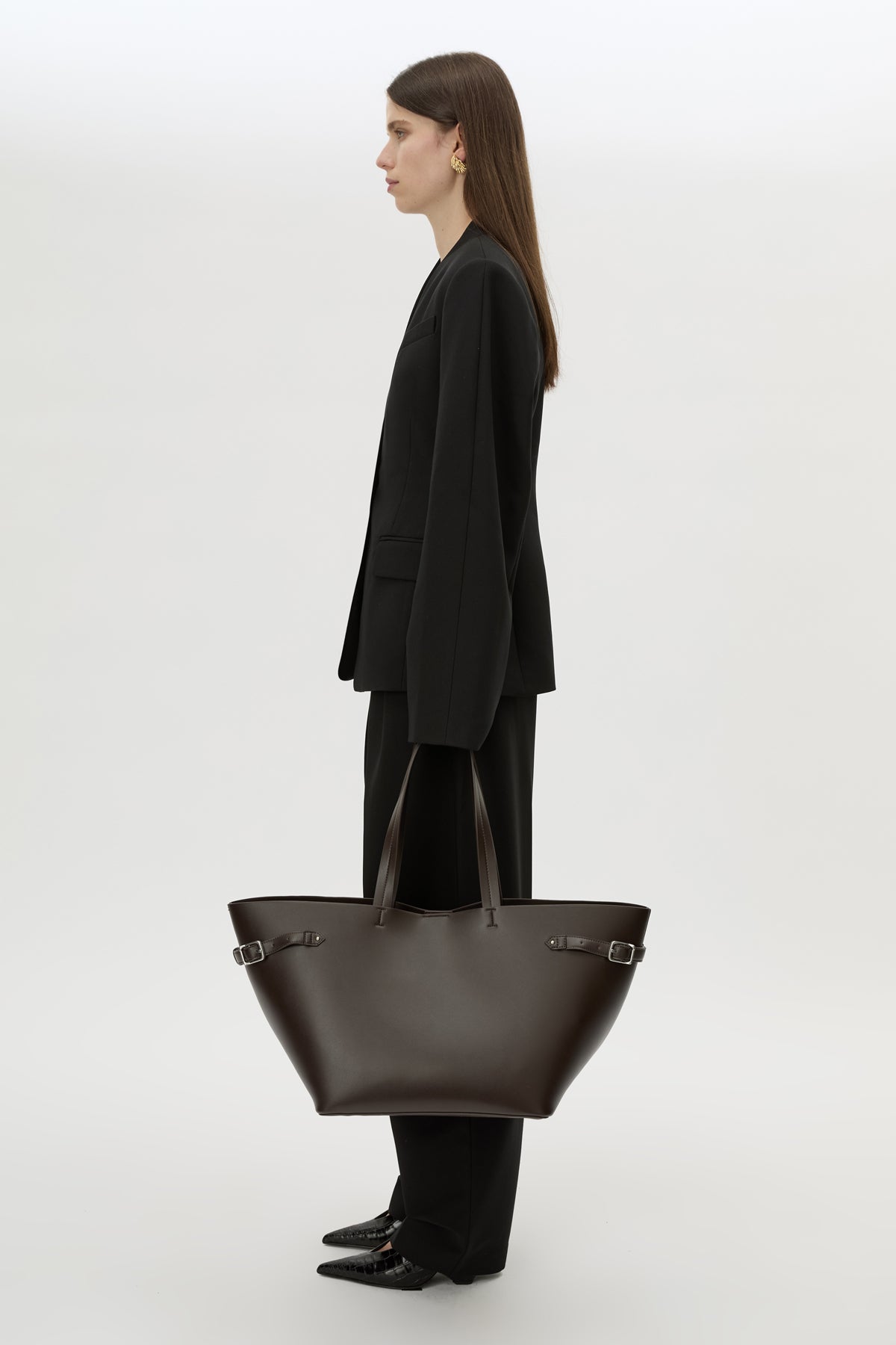 Front styled view CAMILLA AND MARC Willa Tote in Chocolate Brown with side strap and buckle detailing and magnetic button closure.