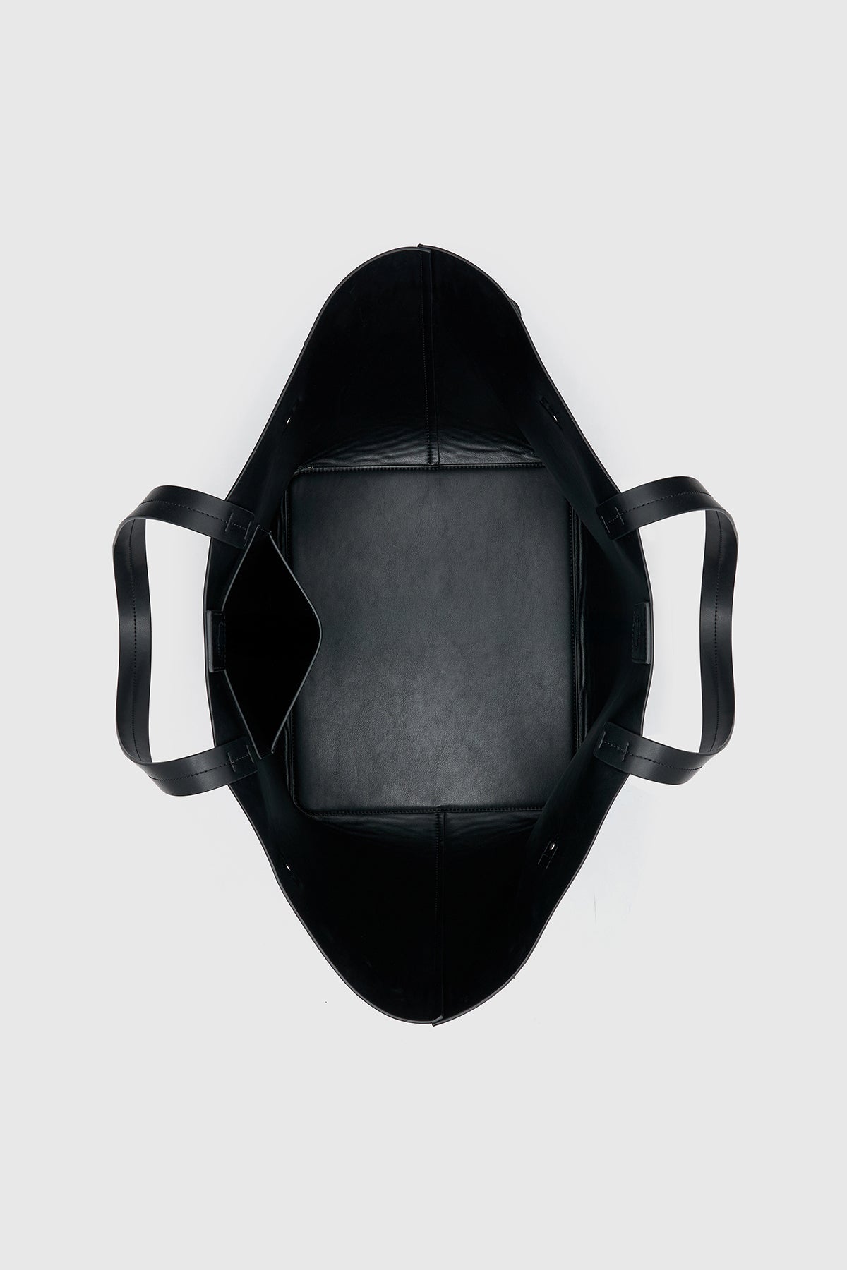 Top view CAMILLA AND MARC Willa Tote in Black with side strap and buckle detailing and magnetic button closure.