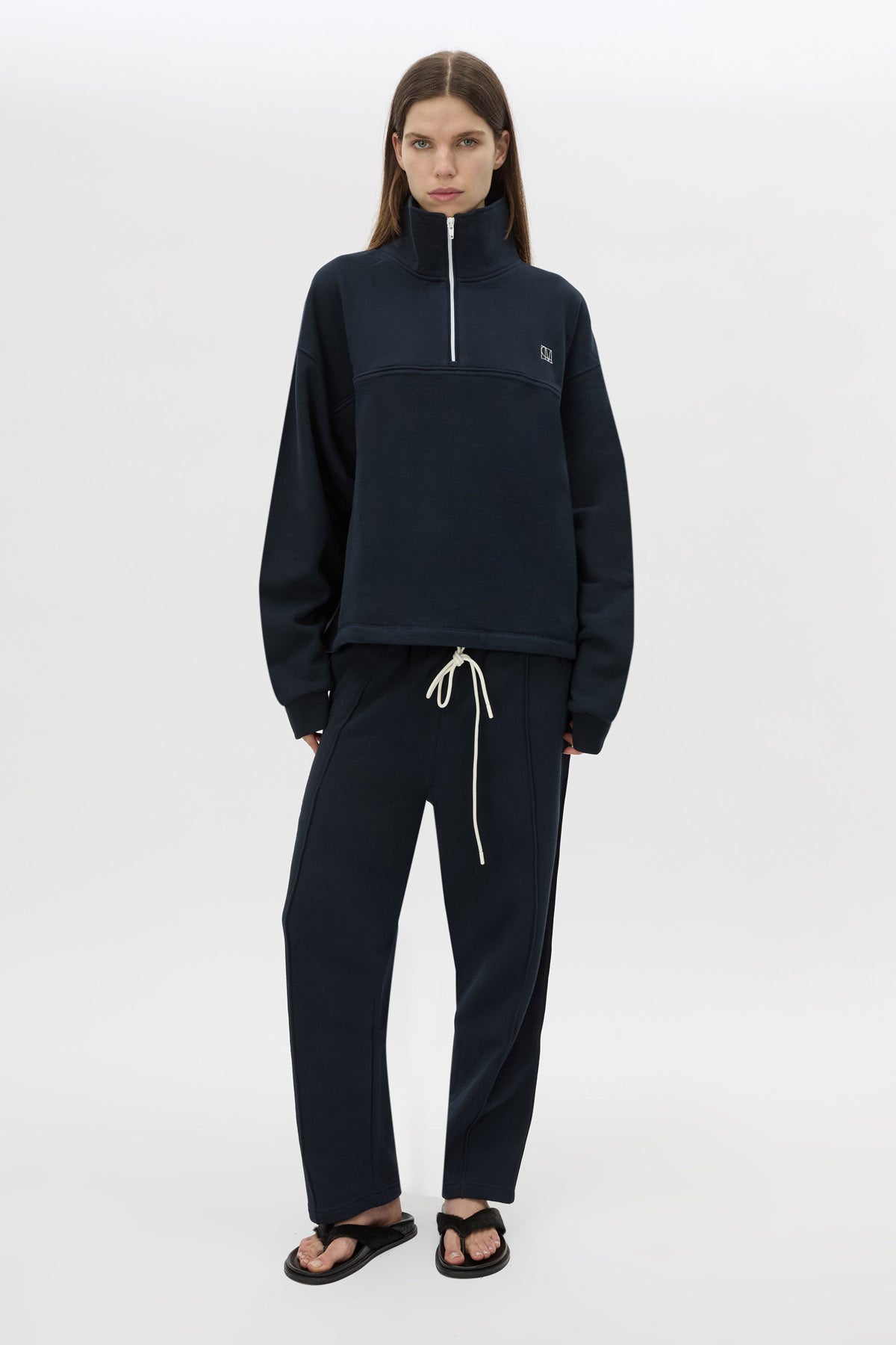Styled view CAMILLA AND MARC Zylus funnel neck pullover sweater in navy/white with contrast embroidered monogram. 