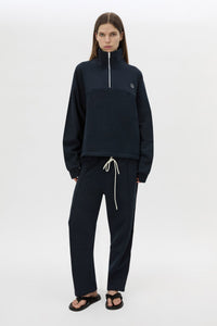 Styled view CAMILLA AND MARC Zylus funnel neck pullover sweater in navy/white with contrast embroidered monogram. 